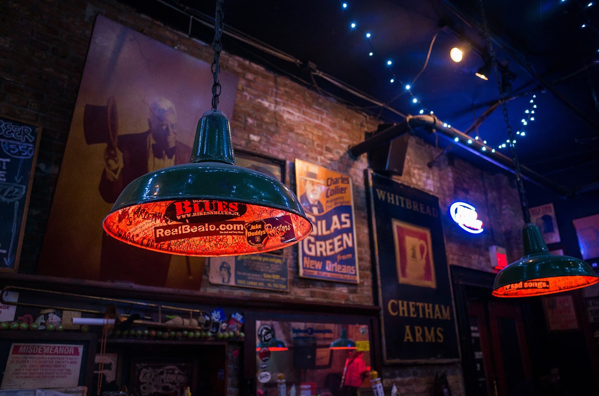 Green pendant lamps covered in blues stickers inside a small bar on Beale Street, Memphis