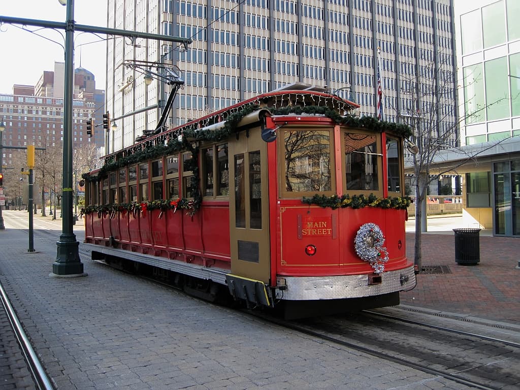 A red Main Street trolley in downtown Memphis trimmed with Christmas garland, a silver wreath and a string of lights