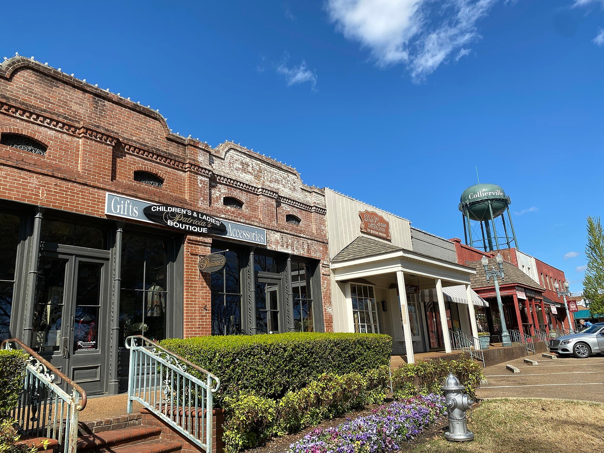 Brick storefronts on the historic Collierville Town Square with the Collierville water tower behind them