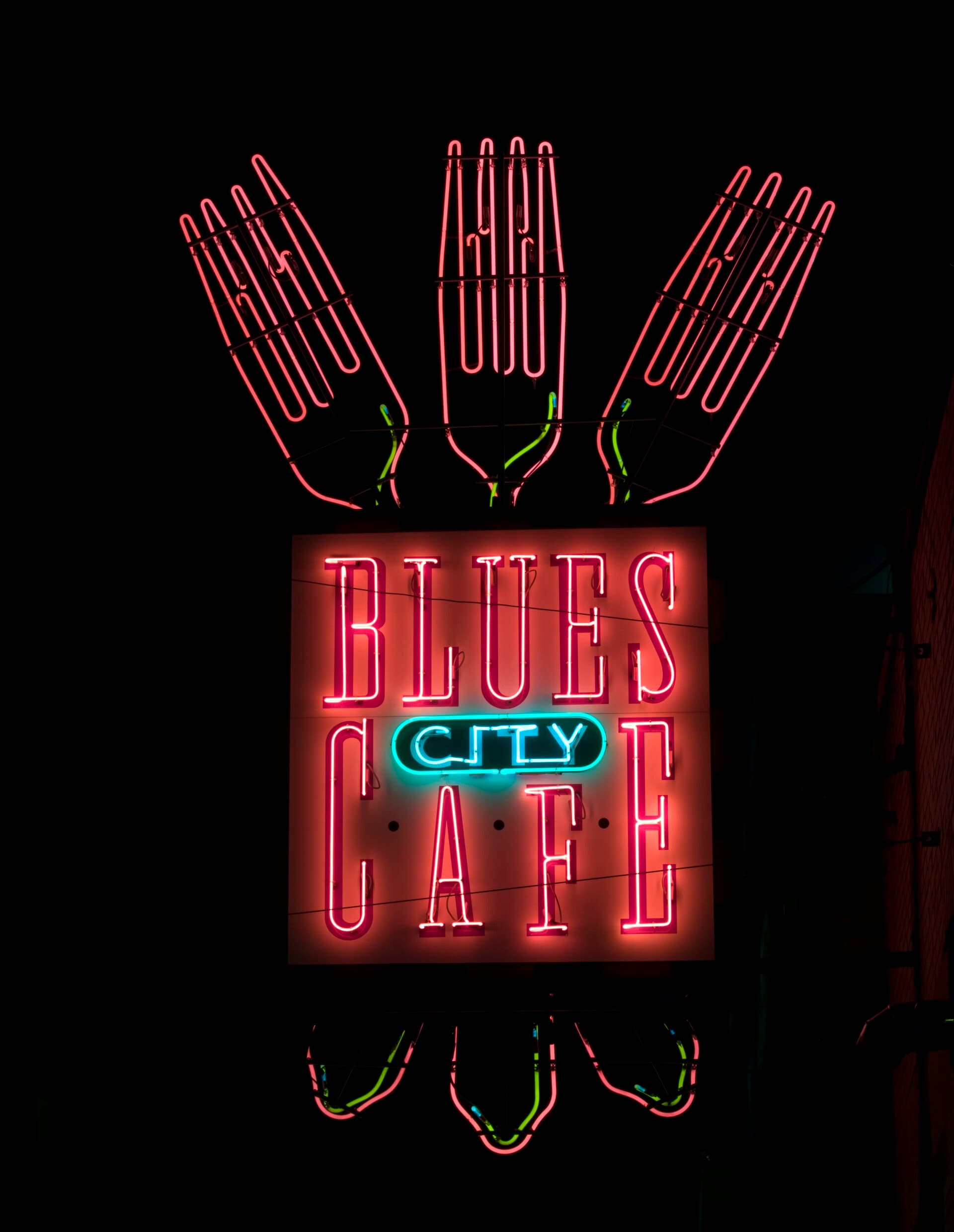 The Blues City Cafe neon sign with three pink neon forks on Beale Street in downtown Memphis