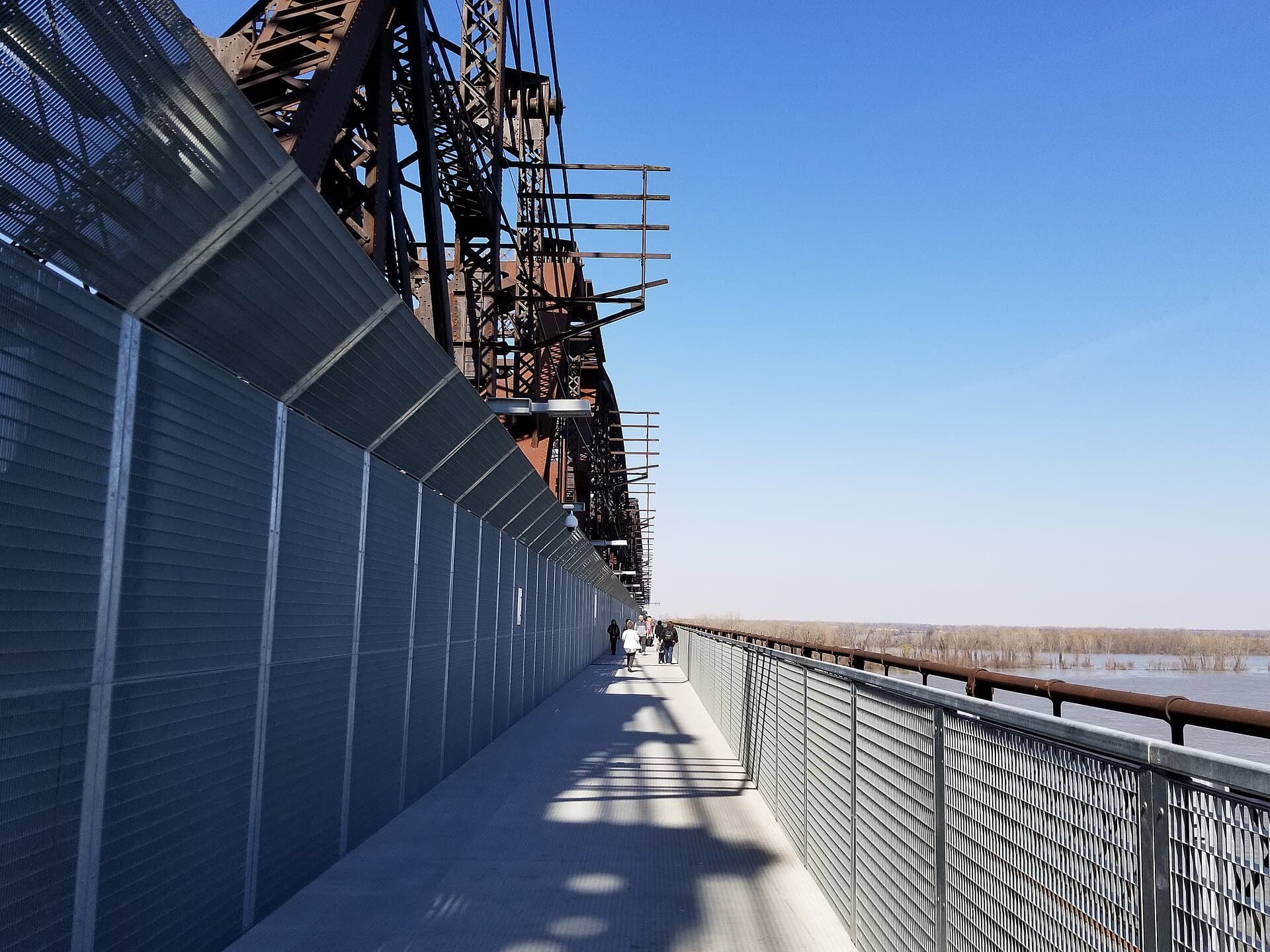 People walking the Big River Crossing boardwalk on the Harahan Bridge over the Mississippi River at Memphis