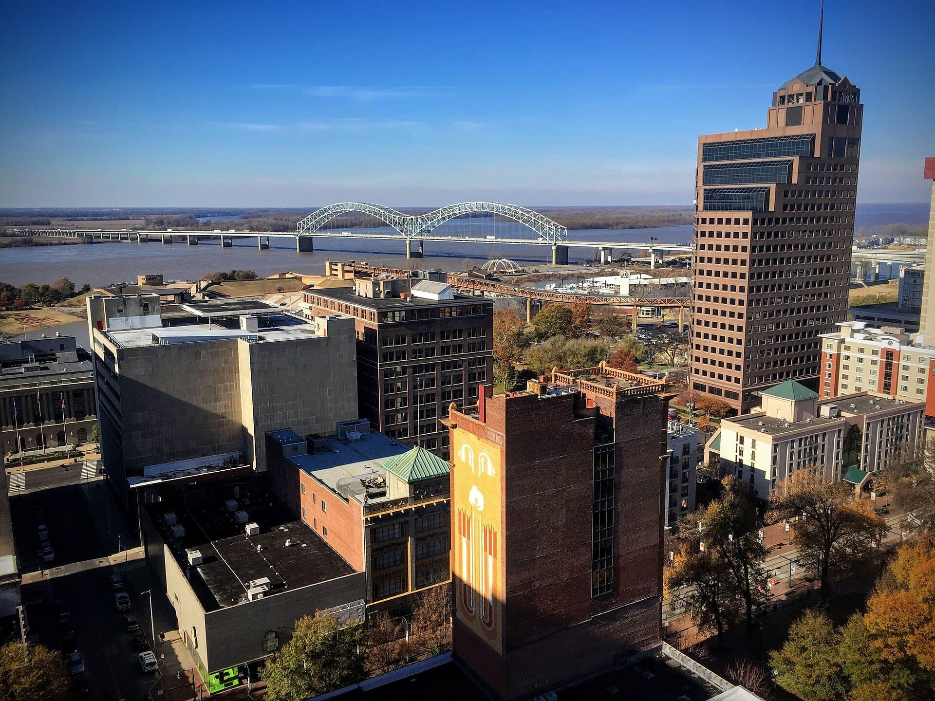An elevated view of the downtown Memphis skyline and the Hernando DeSoto Bridge over the Mississippi River — the view from the city's rooftop bars